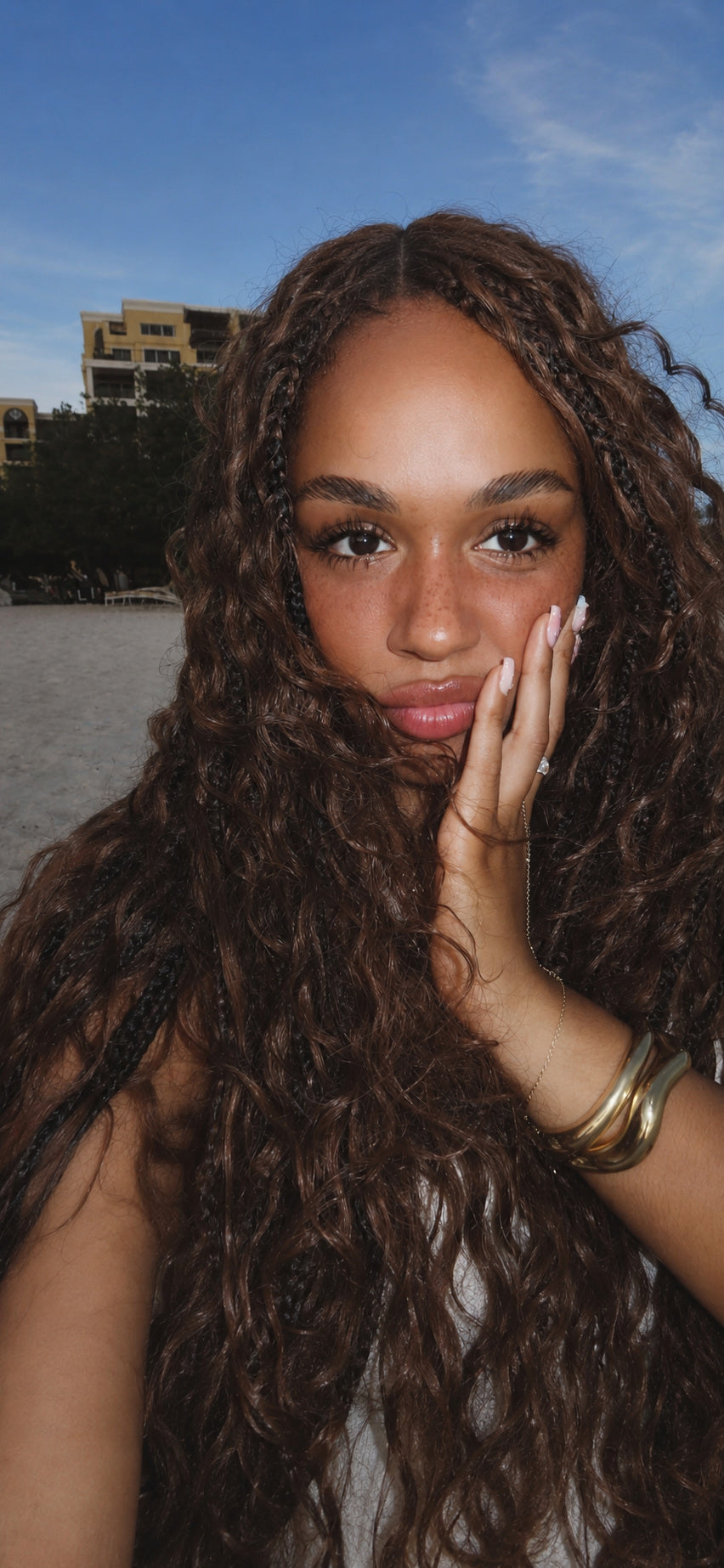 Client wearing long warm-brown HBTBEAUTY boho curls in Aruba